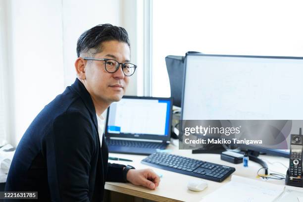 mature japanese business man working in his office - director office photos et images de collection