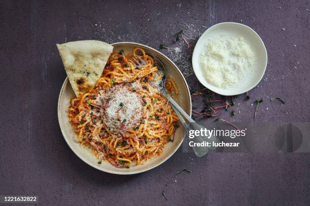 classic spaghetti bolognese with parmesan cheese on purple background - grated stock pictures, royalty-free photos & images