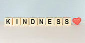 Kindness Word Written In Wooden Cube on a light background