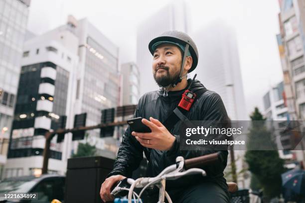 happy bike messenger - rain smiling stock-fotos und bilder