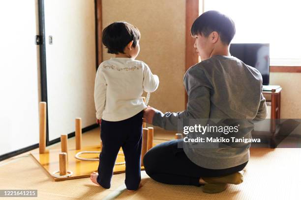 two sisters at home, rear view - ring toss stock pictures, royalty-free photos & images