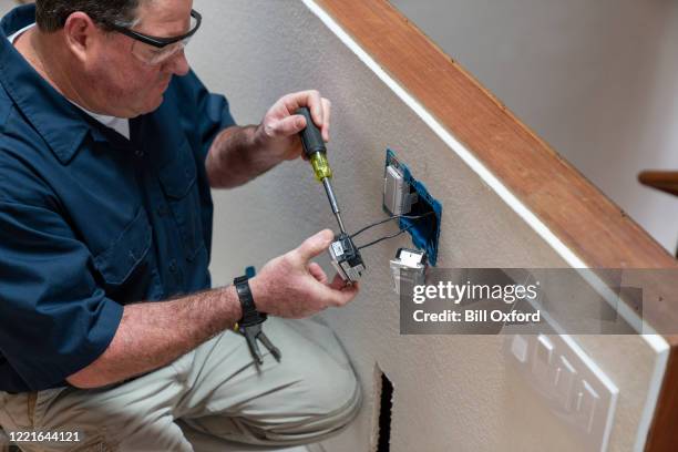 electrician installing light switch in home - light switch box stock pictures, royalty-free photos & images