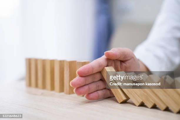 stopping the domino effect concept for business solution, strategy and successful intervention - business continuity stock-fotos und bilder