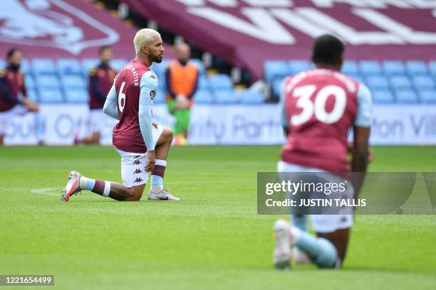 Aston Villa's Brazilian midfielder Douglas Luiz takes a knee to show solidarity with the Black Lives Matter movement against racism during the...