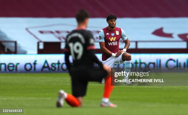 Aston Villa's English defender Tyrone Mings kneels during a minute of silence prior to the English Premier League football match between Aston Villa...