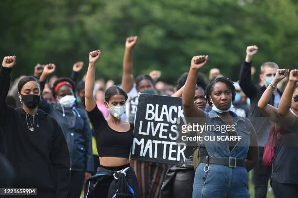 Protesters hold up fists at a gathering in support of the Black Lives Matter movement on Woodhouse Moor in Leeds in northern England on June 21 in...