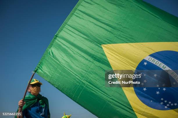 Man is seen and holding a flag of Brazil during a demonstration called &quot;Dia do Basta&quot; in support of the government of President Jair...