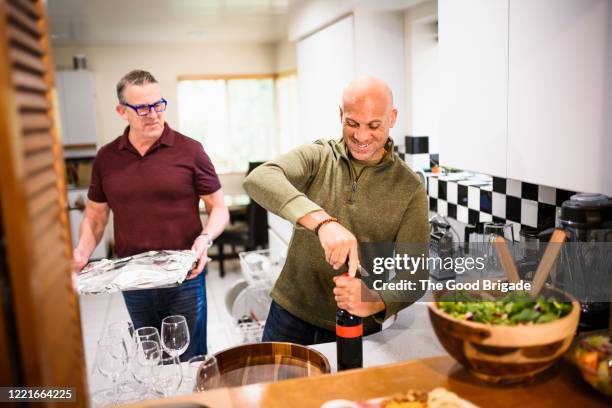 male friends preparing for dinner party in kitchen - the party inside stock pictures, royalty-free photos & images