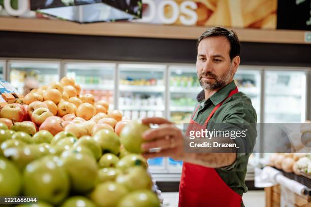 latin american employee in supermarket - employment during pandemic lockdown - greengrocer's shop stock pictures, royalty-free photos & images