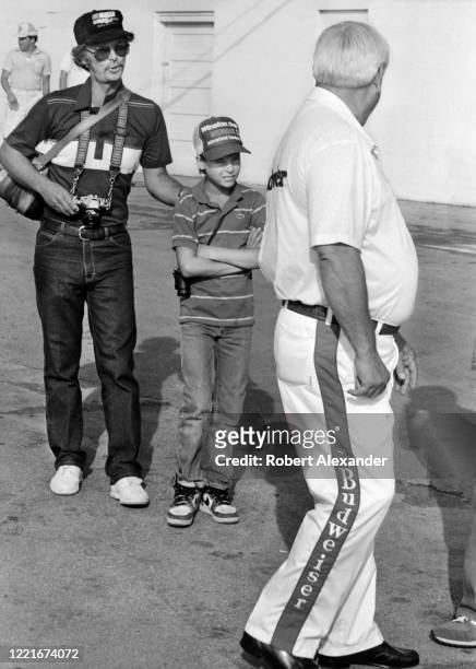 Man and his son approach NASCAR race car owner Junior Johnson in the speedway garage area prior to the start of the 1986 Firecracker 400 stock car...