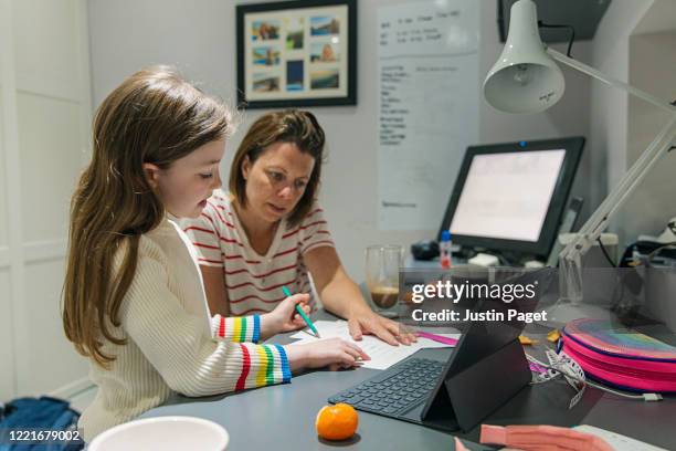 woman helping daughter with her home schooling - instruction à domicile photos et images de collection