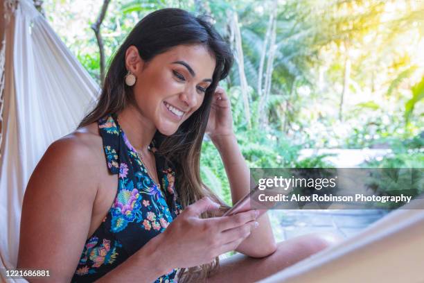 a young woman tourist in a hammock in her hotel villa - trancoso stock pictures, royalty-free photos & images
