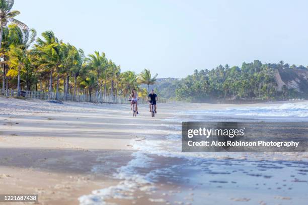 a young woman tourist in a bikini walking along an empty beach - trancoso - fotografias e filmes do acervo