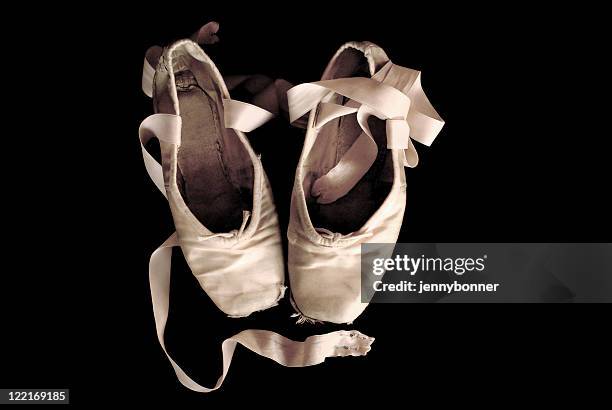 ballerina: worn out ballet pointe shoes black background - pointe stock pictures, royalty-free photos & images