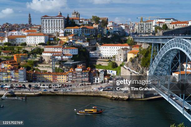 Rabelo port wine barge and The Ponte de Dom Luis I - metal arch bridge over River Douro connecting Porto to V|la Nova de Gaia, Portugal.