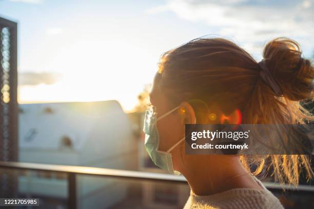 woman looking from her balcony at sunset. - aussie flu stock pictures, royalty-free photos & images