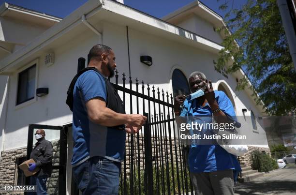 Homeless man tries on a protective mask after receiving a health care package at the Greater St. Paul Baptist Church on April 28, 2020 in Oakland,...
