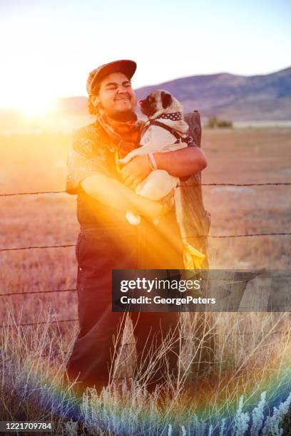 young hippie man holding pet pug - bohemian fashion men stock pictures, royalty-free photos & images
