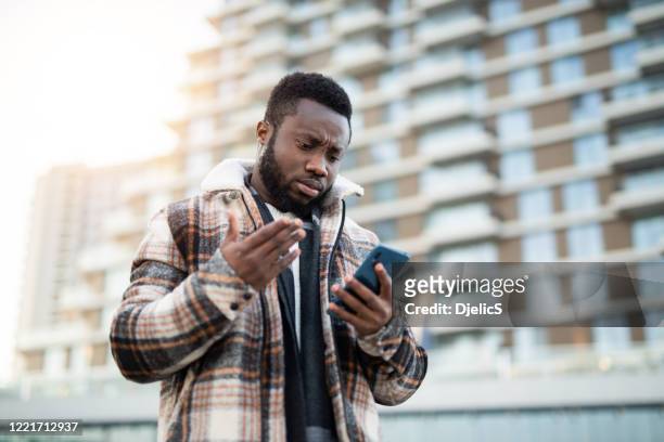 frustrated young man using phone. - frustração imagens e fotografias de stock