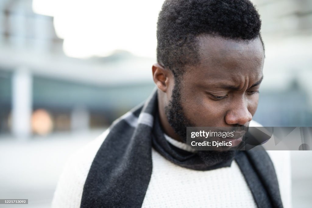 Anxious young man looking down.