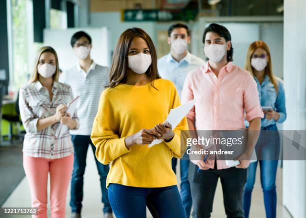 group of people working at a creative office wearing facemasks - medium group of people stock pictures, royalty-free photos & images