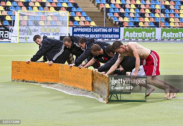 Employees try to slide the water from the pitch with banks as the the European Field Hockey championships in Monchengladbach were hit by heavy rain...