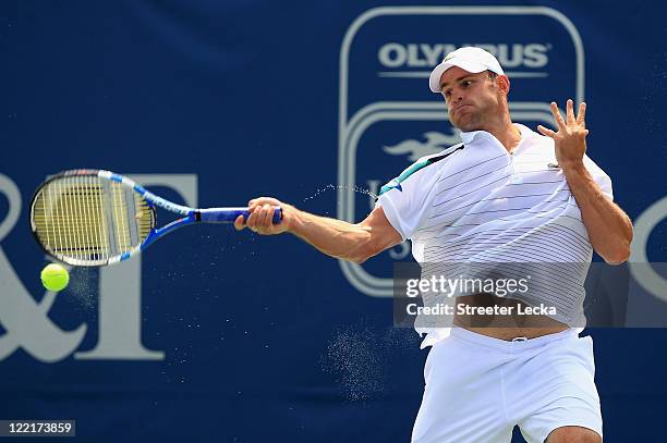 Andy Roddick of the USA returns a shot to John Isner of the USA during the semifinals of the Winston-Salem Open at the Wake Forest University Tennis...