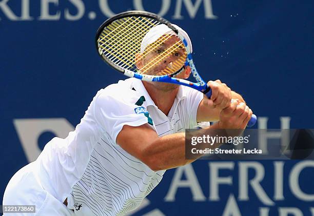 Andy Roddick of the USA returns a shot to John Isner of the USA during the semifinals of the Winston-Salem Open at the Wake Forest University Tennis...