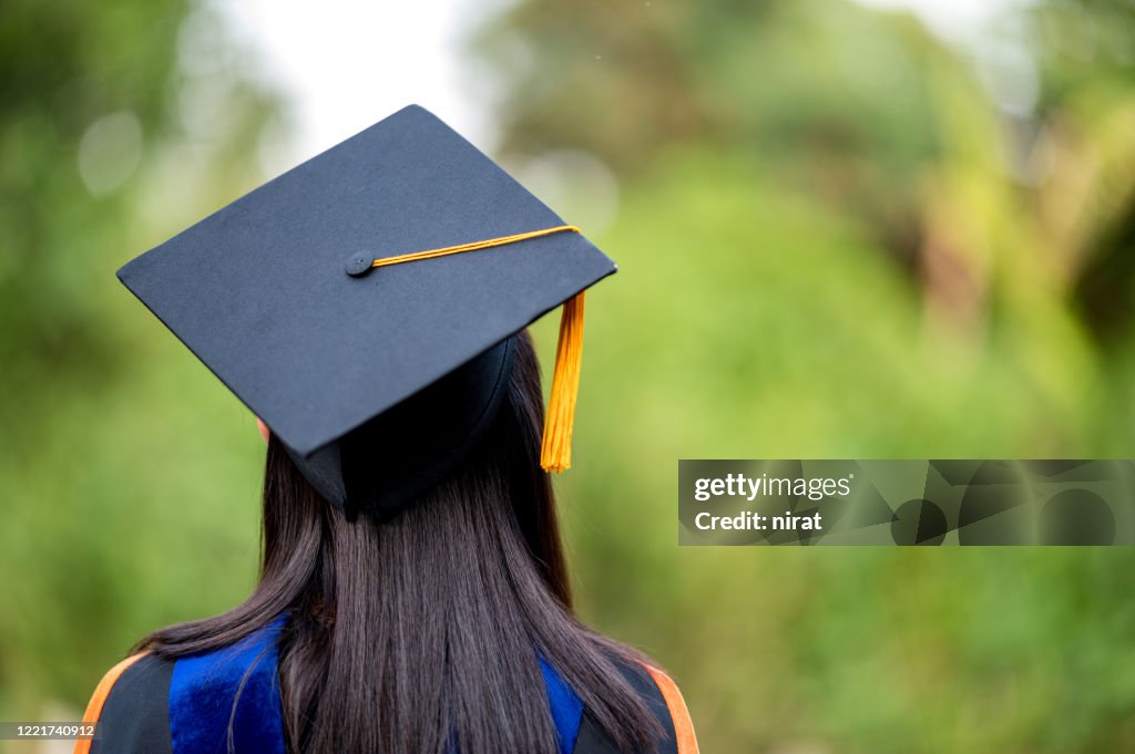 Closeup behind a female college graduate wearing a black fringe gown and a black hat, Concept of Successful Education in Hight School,Congratulated Degree