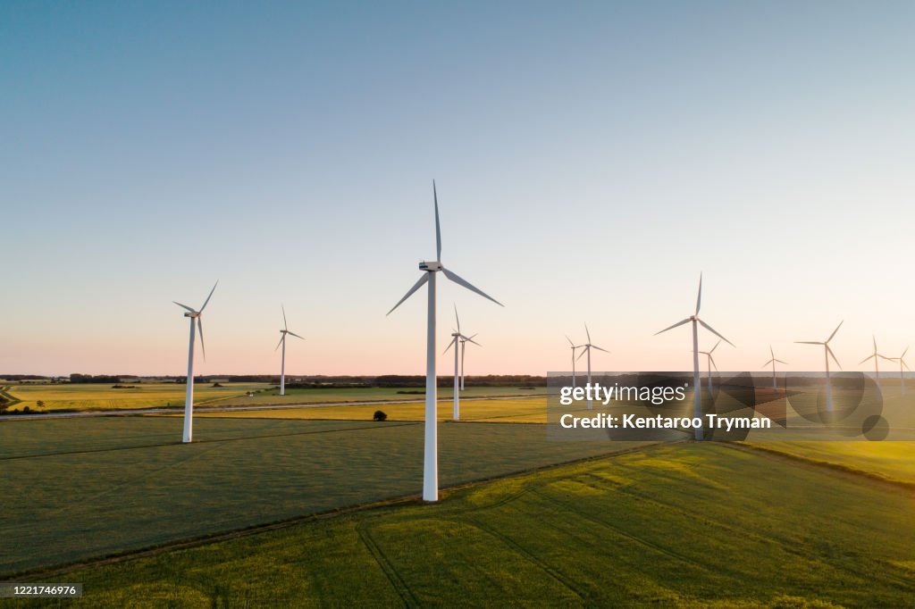 Wind turbines on agricultural land against clear sky