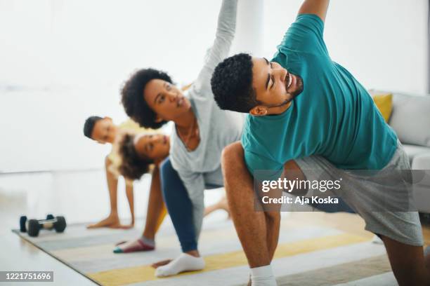 family exercising at home. - family yoga stock pictures, royalty-free photos & images