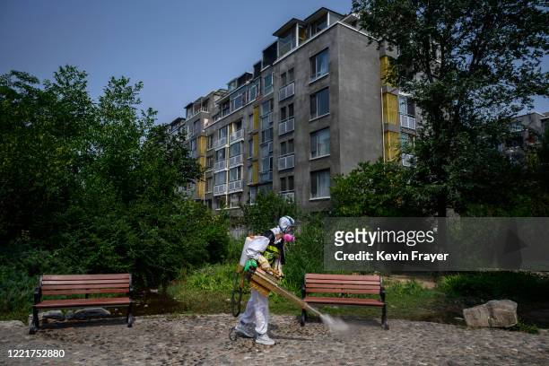 Chinese member of Blue Sky Rescue wears a protective suit as he fumigates to prevent COVID-19 at a residential compound on June 21, 2020 in Beijing,...