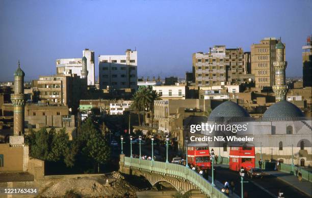 Double Decker buses cross the Al Shuhada bridge over the Tigris River in central Baghdad circa 1978;