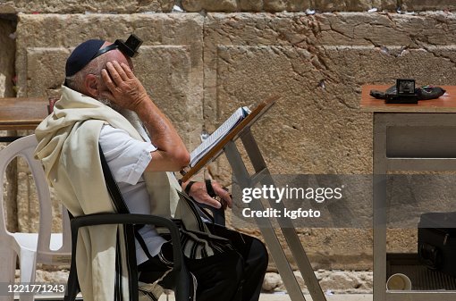 Old religious jewish man with tefillin, yarmulke praying at Western Wall, Wailling Wall, Kotel in Jerusalem Old City. Israel