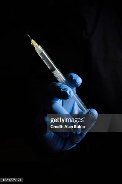 nurse holding a syringe before using it as a vaccine - surgical needle stock pictures, royalty-free photos & images