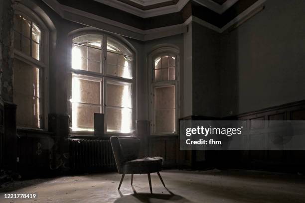 chair in an empty room in an abandoned building - horror room stock pictures, royalty-free photos & images