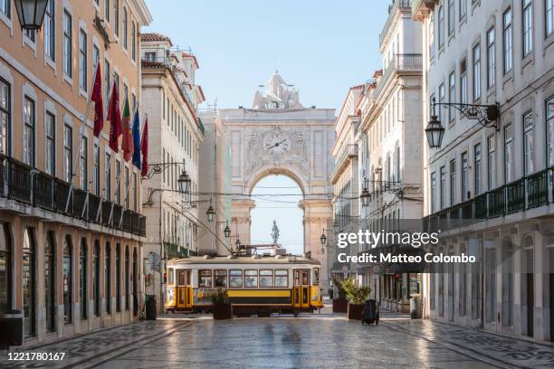 tram in front of rua augusta arch, lisbon, portugal - portogallo foto e immagini stock