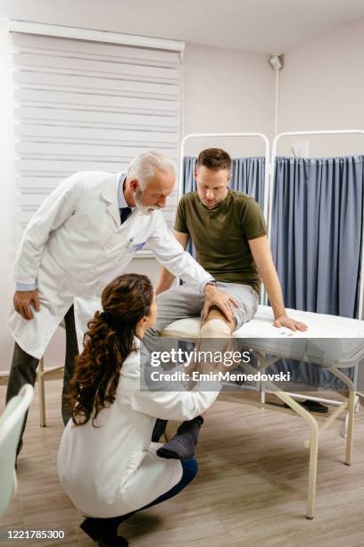 nurse rewinding knee bandage - accident hospital stock pictures, royalty-free photos & images