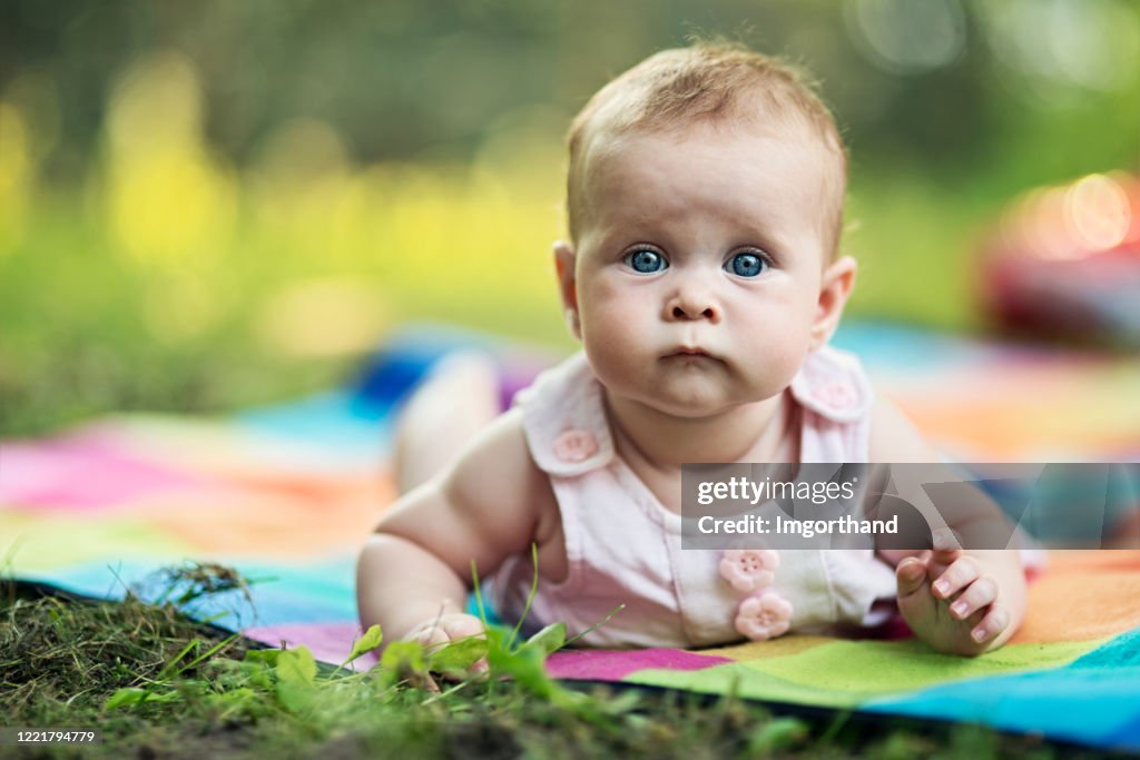 Porträt von super niedlichen Baby-Mädchen auf Decke im Hinterhof