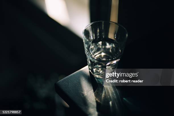 glass of water on bedside table - bedside table stock pictures, royalty-free photos & images