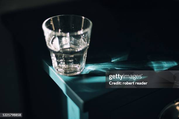 glass of water on bedside table - bedside table stock pictures, royalty-free photos & images