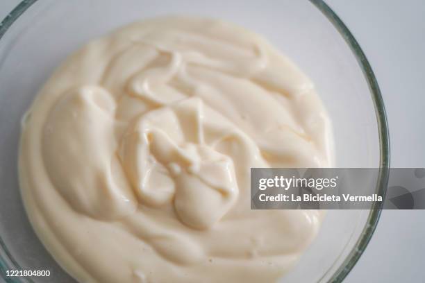 homemade mayonnaise in glass bowl on white table - mayonnaise stock-fotos und bilder