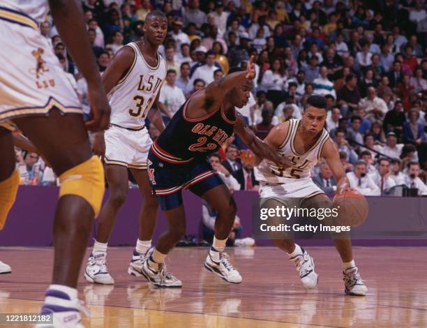 Chris Jackson, Guard for the Louisiana State University Fighting Tigers dribbles the ball past Tim Jumper, Guard for the University of Mississippi...