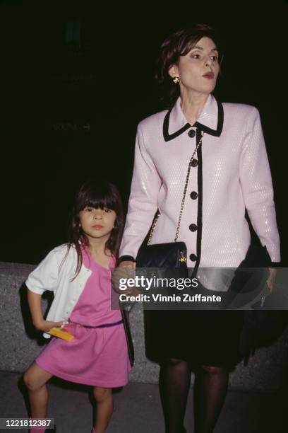 American women's rights attorney Gloria Allred holds the hand of a young girl as they attend a benefit performance of stage musical 'Beauty And The...