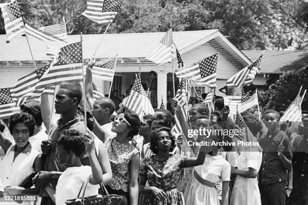 Demonstrators wave the American flag during a civil rights march in Jackson, Mississippi, 17th June 1963.