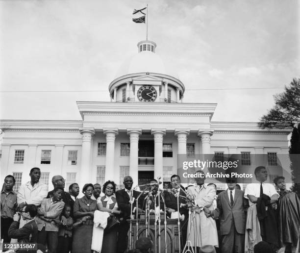 Leaders of Selma to Montgomery march, in protest of voter registration laws in Alabama, join hands outside the State Capitol building, a Confederate...