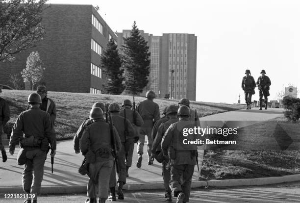 National Guardsmen patrol Kent State University campus after a day's violence ended with four students killed and several others injured.