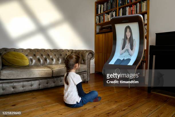 Girl attending an online class with a giant smartphone