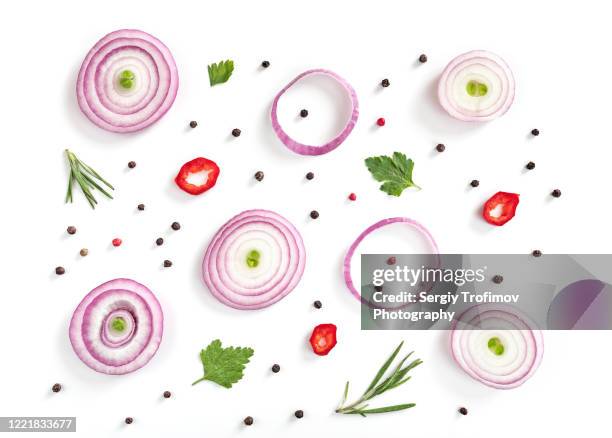 red onion slices with pepper corns and herbs on white background - red onion stockfoto's en -beelden