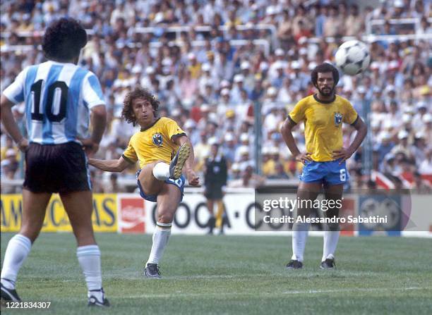 Arthur Antunes Coimbra Zico kicks the ball while Leovelgido Lins Da Gama Junior of Brazil and Diego Armando Mardona of Argentina look on during the...